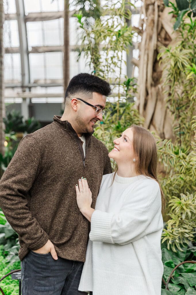Couple standing side by side looking at one another and smiling for their Chicago engagement session.
