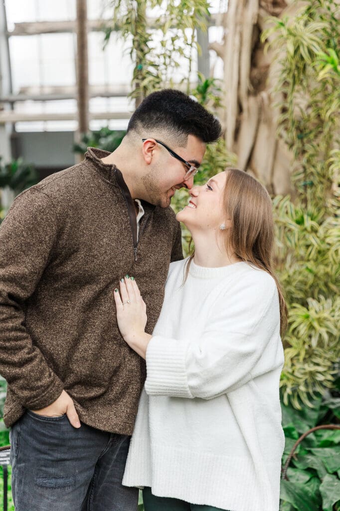 Couple standing close together touching their noses together and smiling at one another during their engagement session in Chicago with Sierra Marie Photography.