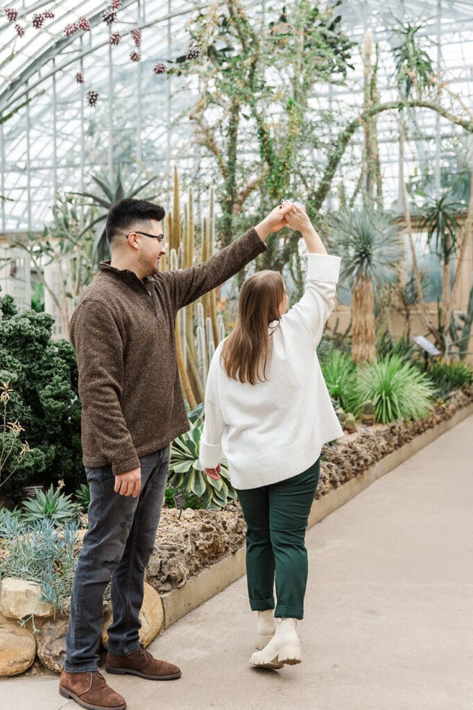 A couple spending time together dancing during their engagment session at Garfield Park Conservatory