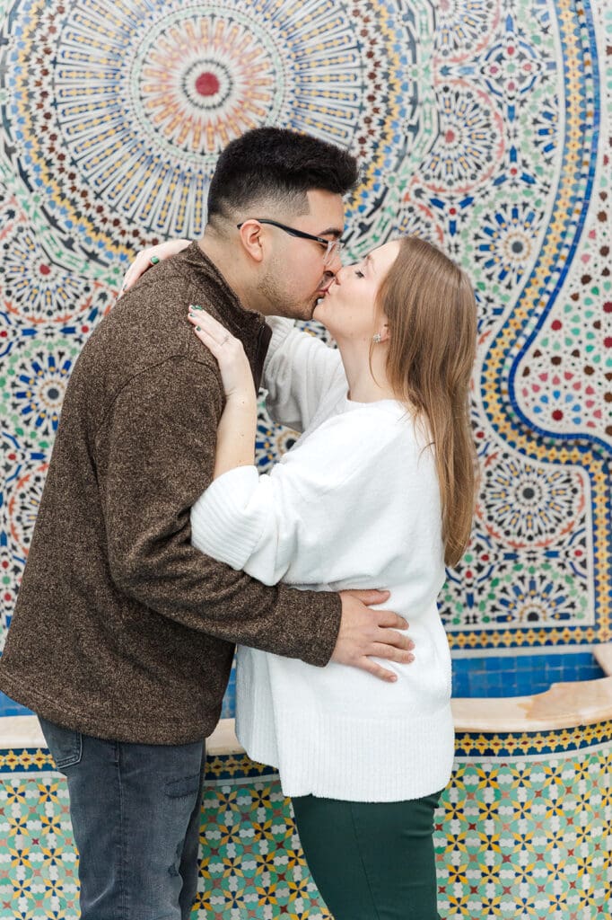 A couple kissing at the mural during their engagement session at Garfield Park Conservatory in Chicago