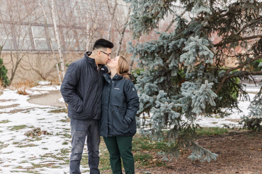 couple dressed in winter coats during their Garlfield Park Conservatory engagement session in the winter